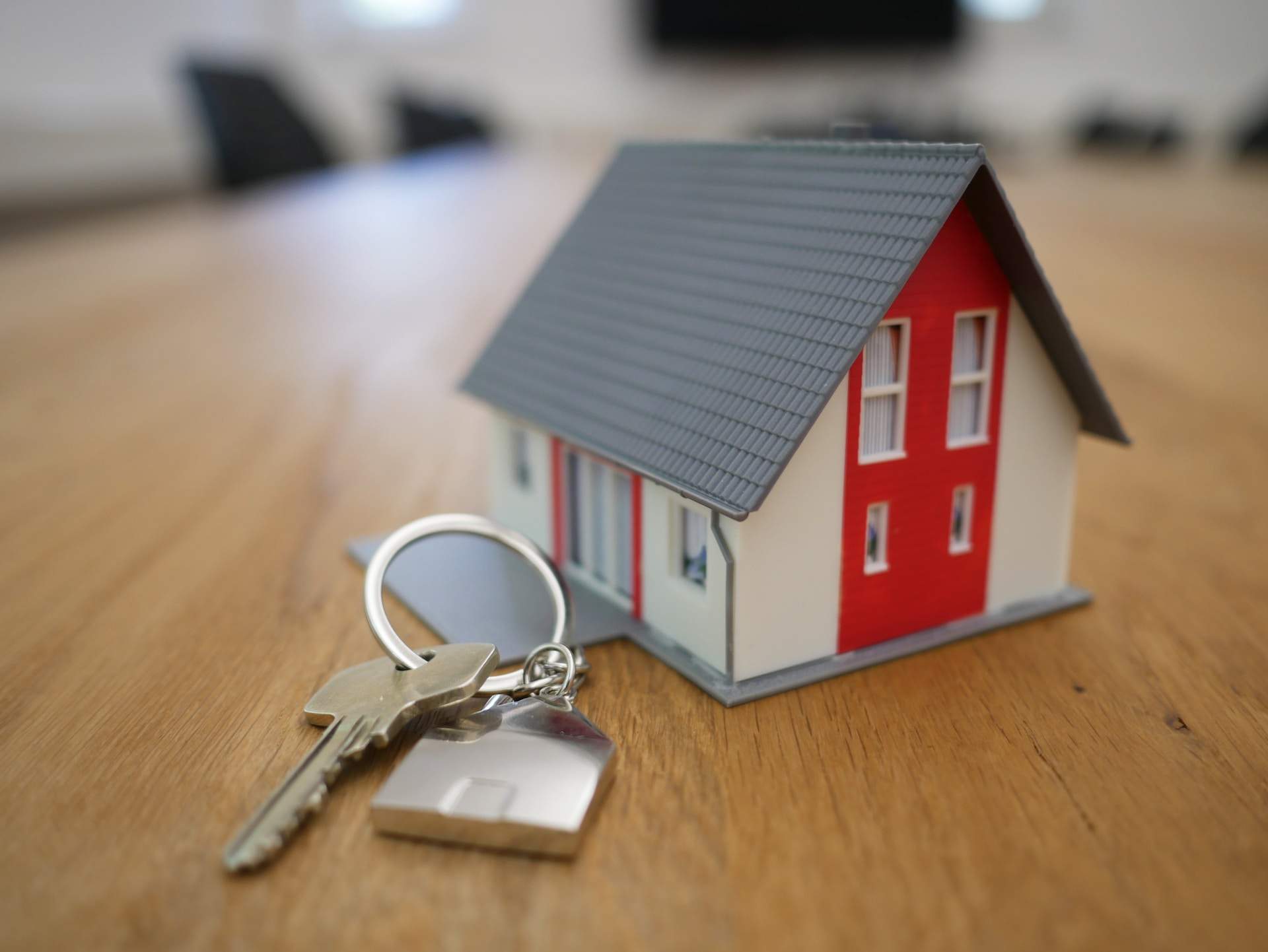 Model house next to a house key on a keychain