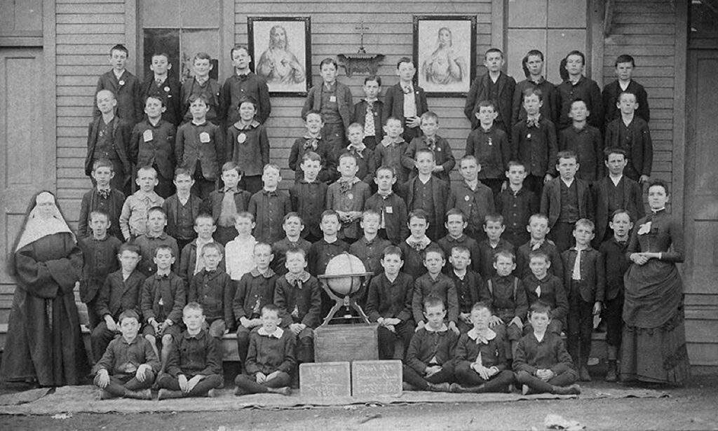 Sister Mary Margaret McCabe poses with students at Immaculate Conception Elementary School in 1888.