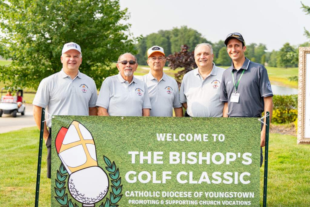 group shot in front of bishop golf classic banner