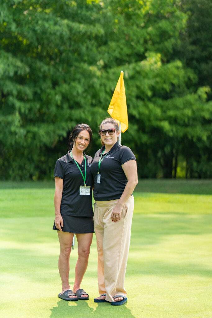two female volunteers pose on the course