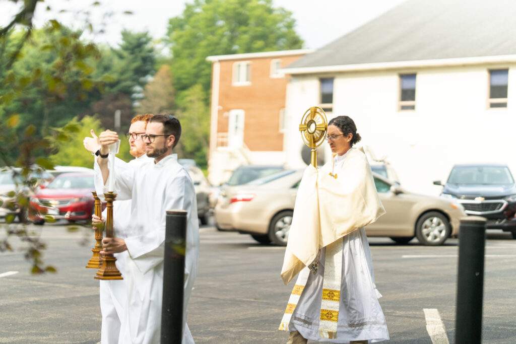 Father Brian smith processes with the Eucharist