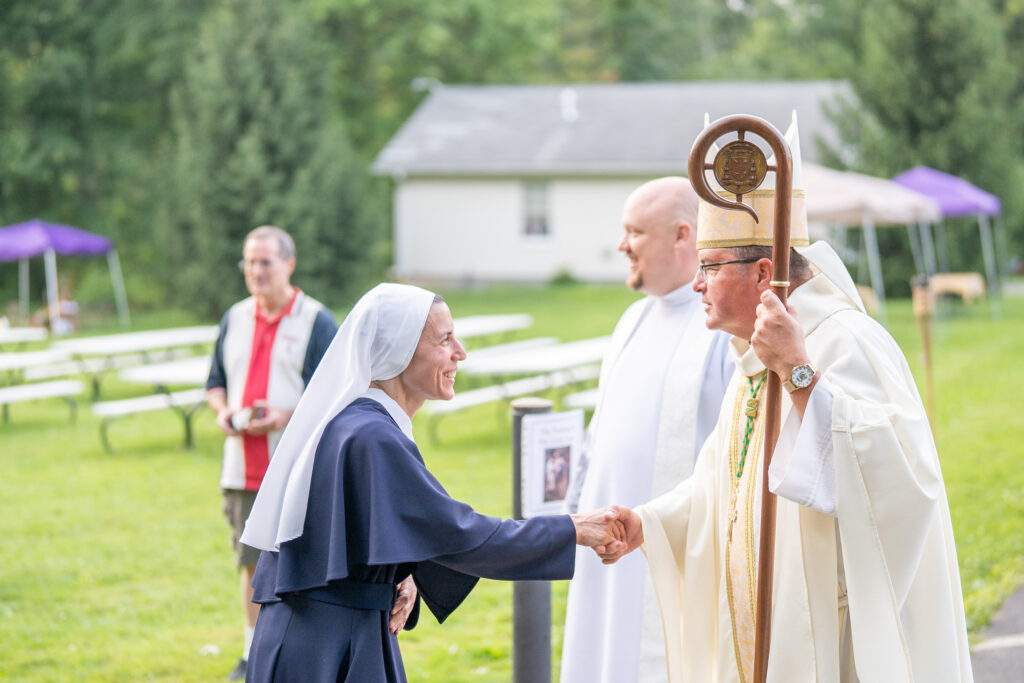 Bishop shakes hand of religious sister after Mass