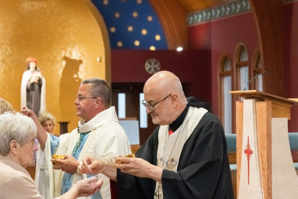 Bishop distributes communion with Maronite priests at assumption pilgrimage in North Jackson