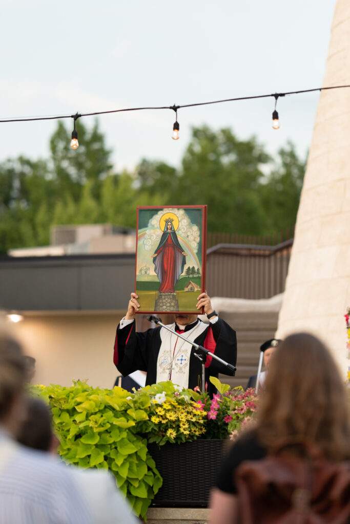 Maronite priest holds an image of Mary over his head