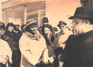 Black and white photo of Father Friedrich being received by a crowd.