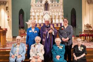Seated in the front are Sisters Barbara Hermann, Margaret Mary Siegfried, Mary John Albert Thiry and Marjorie King, standing with the bishop are Sisters Barbara Klodt and Kristin Matthes.