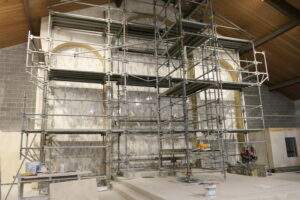 Scaffolding surrounds bare, burnt walls of the altar.