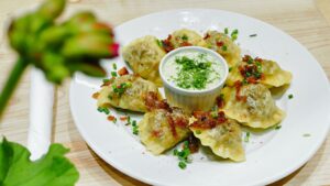 plate of pierogis with sour cream and garnish