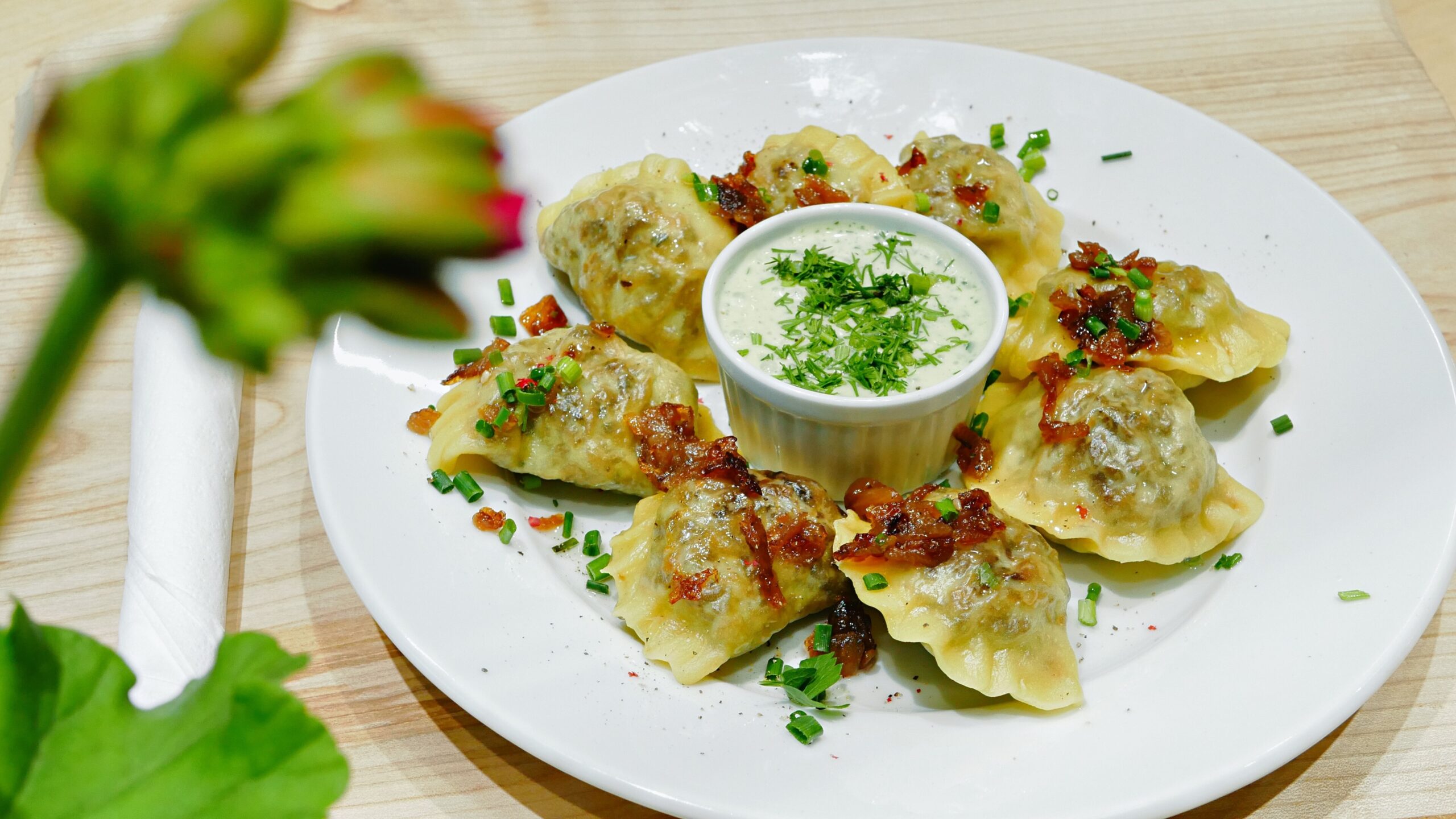 plate of pierogis with sour cream and garnish
