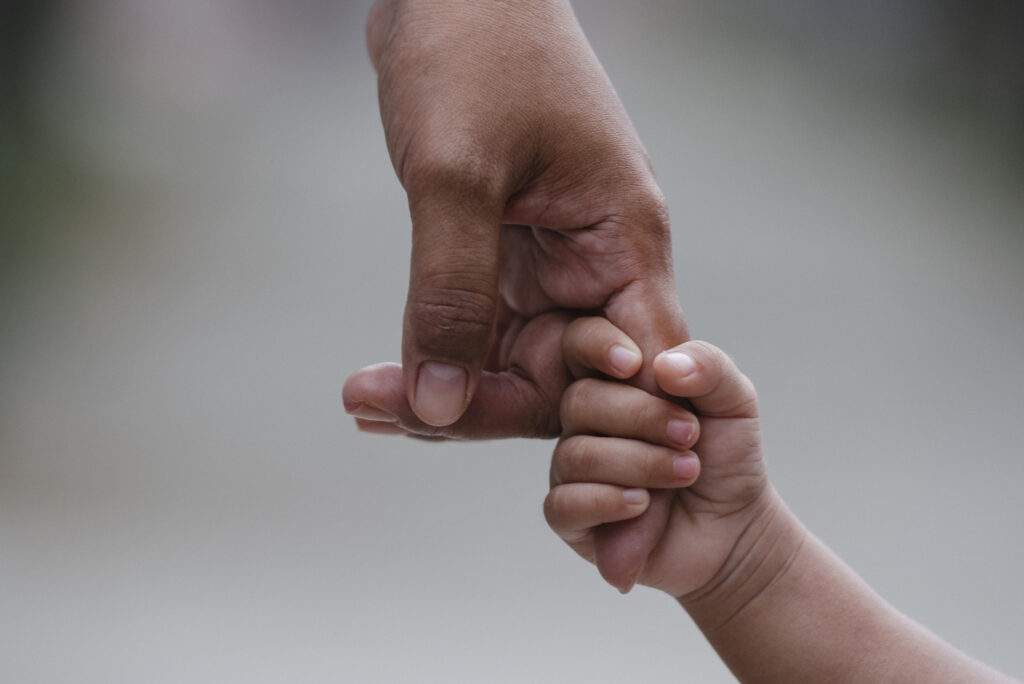 Parent holds child's hand