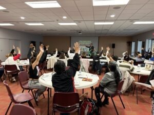 Attendees raise their hands at the seminar