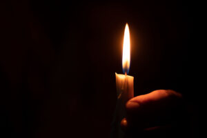 Hand holding taper candle.