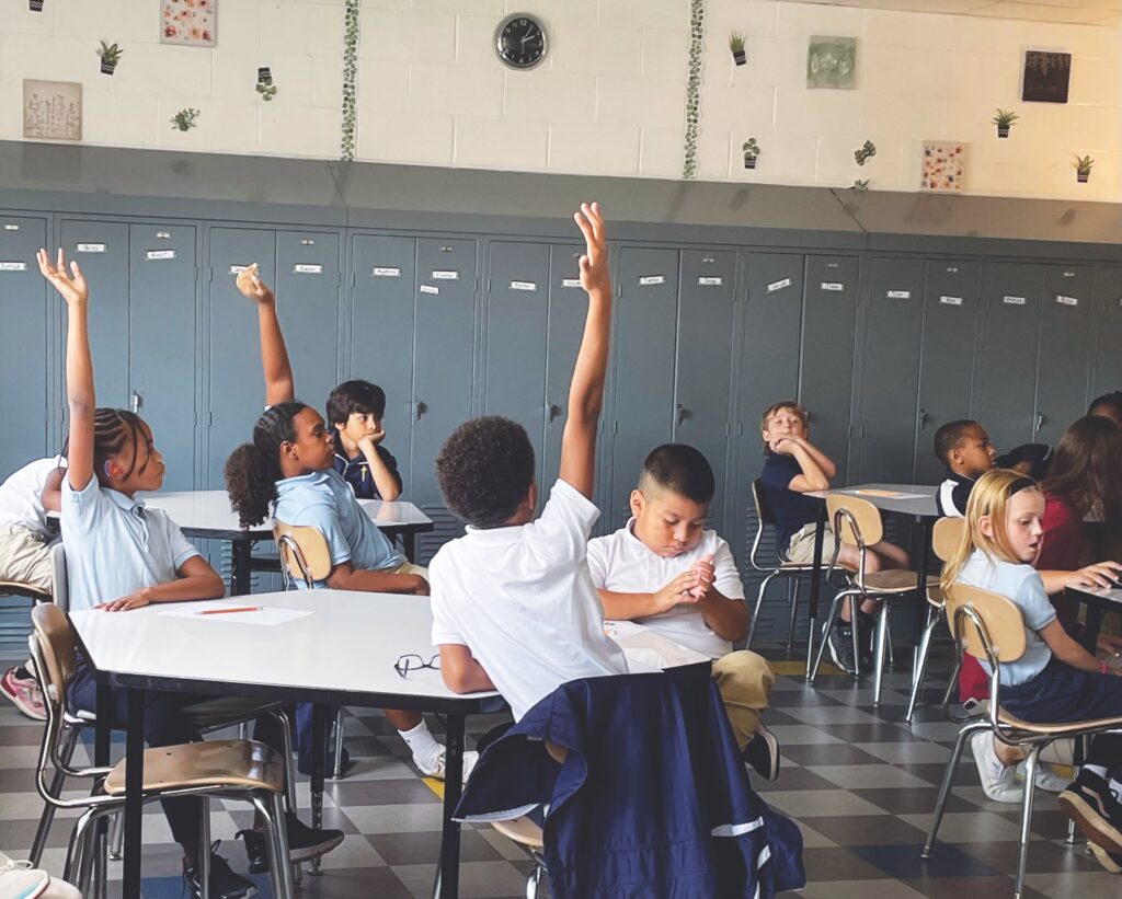 kids raise hands during class