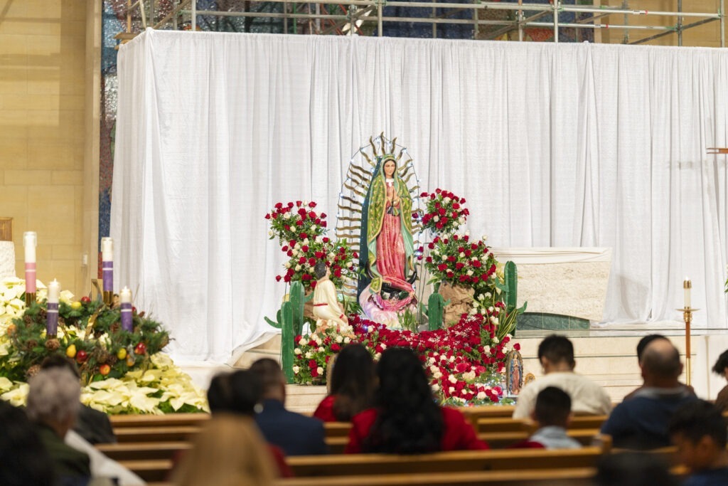 Statue of Our Lady of Guadalupe in front of the Altar, surrounded by flowers