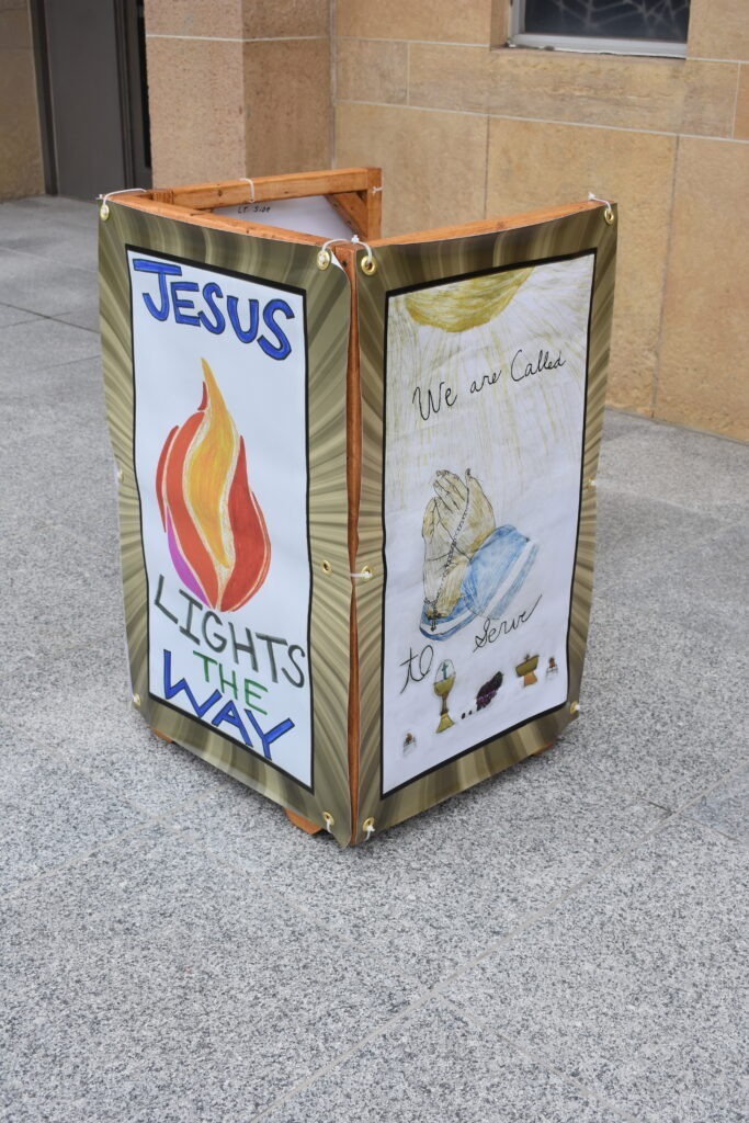 Light cover that features art reading "Jesus Lights the Way" in front of St. Columba Cathedral