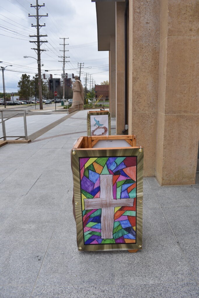 Light cover featuring an image of a stained glass cross, in front of St. Columba Cathedral