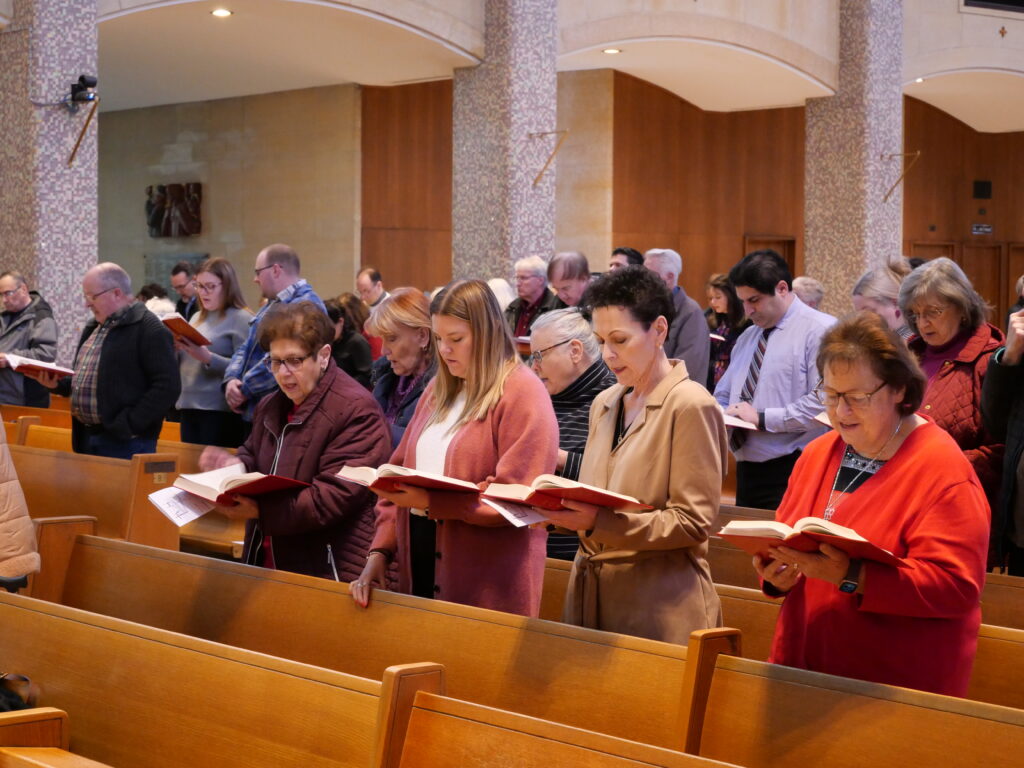 Diocesan employees sing a hymn during Ash Wednesday Mass at St. Columba Cathedral