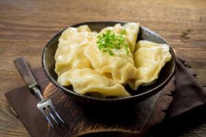 Dumplings, filled with cheese in bowl on wooden table.