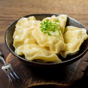 Dumplings, filled with cheese in bowl on wooden table.