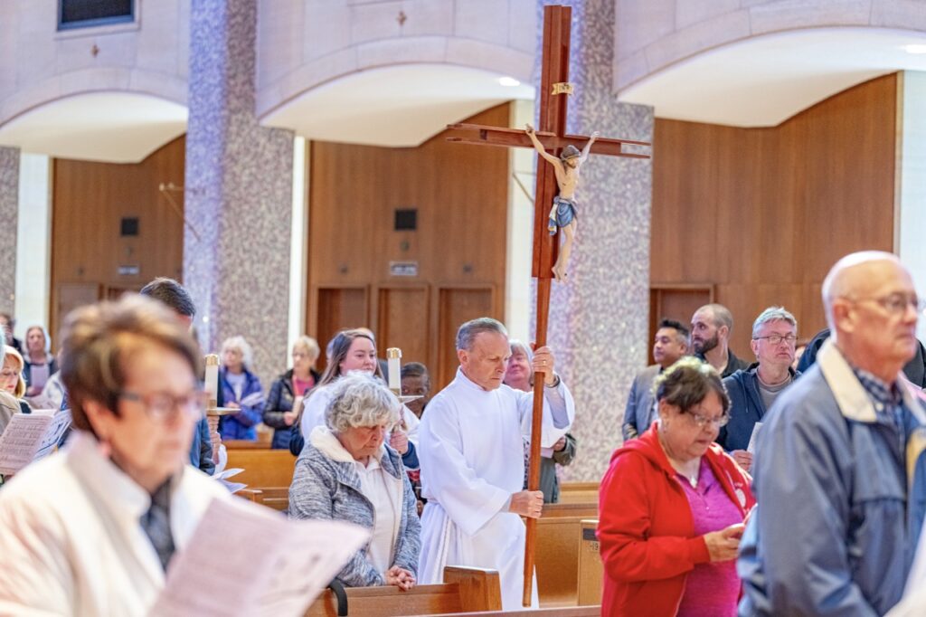 Server walks in procession with the processional cross during Holy Thursday 2024. Photo by Brian Keith.