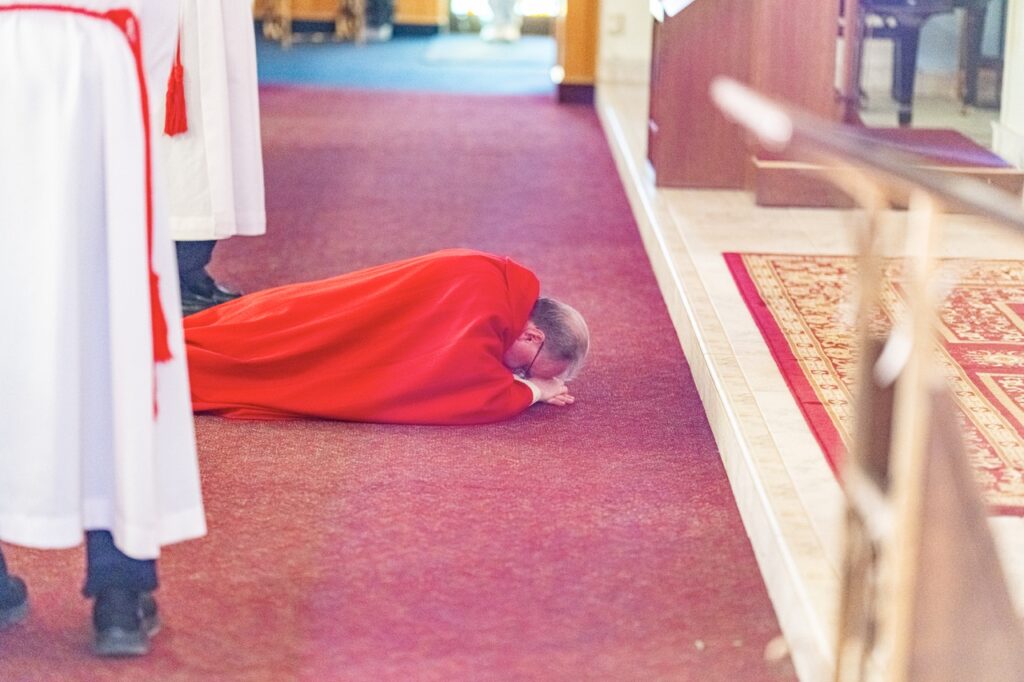 Priest lays prostrate at Good Friday Liturgy 2024 at St. Mary and St. Joseph Parish in Newton Falls. Photo by Brian Keith.