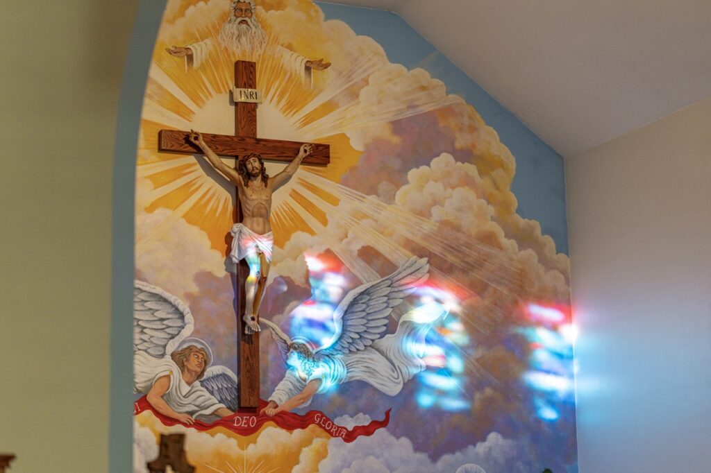 Image of colorful sunlight touching the crucifix above the altar at Good Friday Liturgy 2024 at St. Mary and St. Joseph Parish in Newton Falls. Photo by Brian Keith.