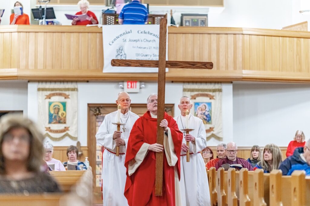 Priest processes with the cross at Good Friday Liturgy 2024 at St. Mary and St. Joseph Parish in Newton Falls. Photo by Brian Keith.
