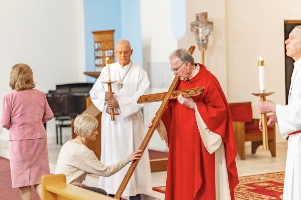 Woman kneels and touches the cross at Good Friday Liturgy 2024 at St. Mary and St. Joseph Parish in Newton Falls. Photo by Brian Keith.