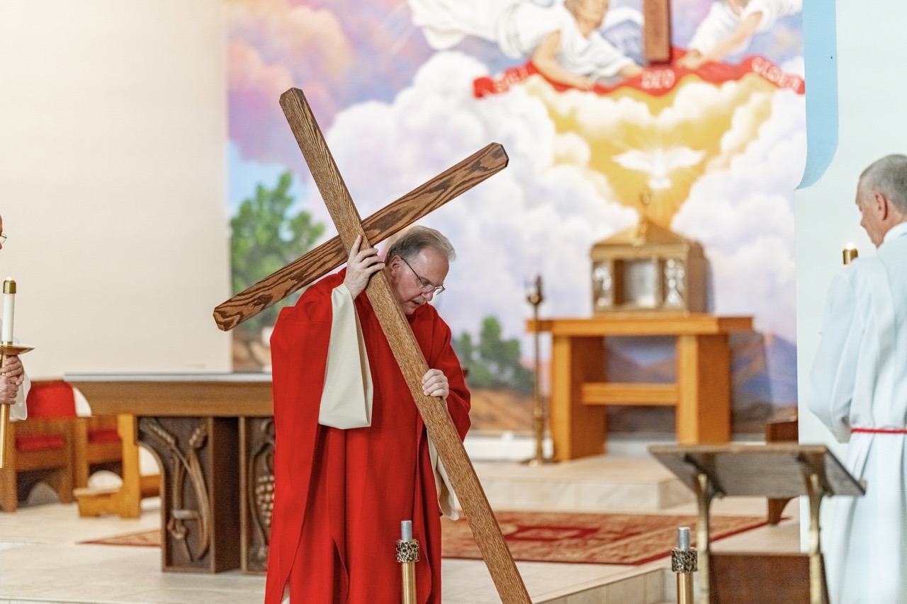 Priest carries the cross at Good Friday Liturgy 2024 at St. Mary and St. Joseph Parish in Newton Falls. Photo by Brian Keith.
