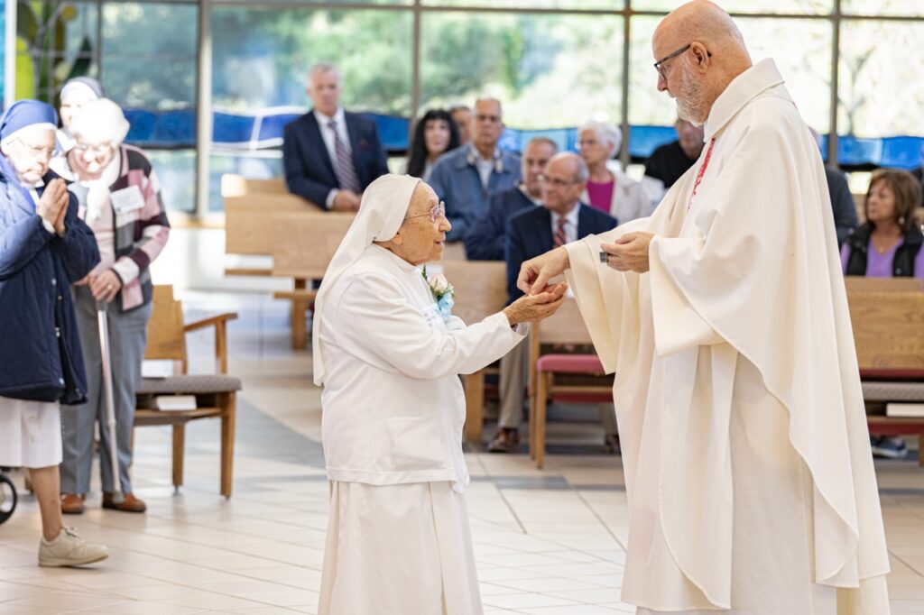 75-year Jubilarian receives communion at her jubilee Mass. Photo by Brian Keith. 