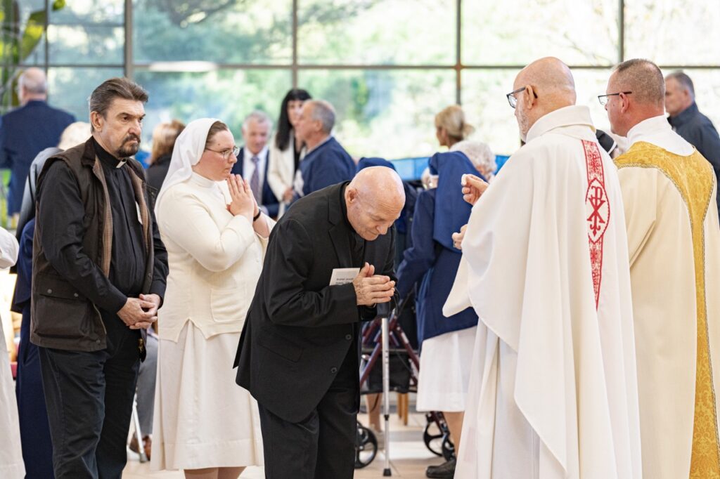 Religious father receives communion at his jubliee Mass. Photo by Brian Keith. 