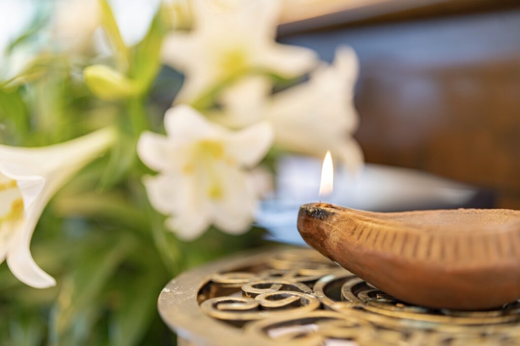 photo of incense, with lillies in the background. Photo by Brian Keith. 