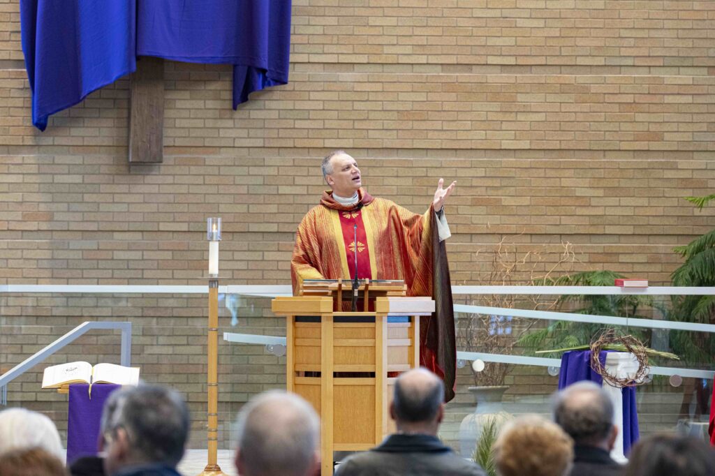 Father Celuch delivers his homily, pointing to the sky. Photo by Brian Keith