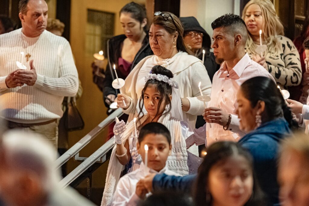 First holy communion candidate stands with her candle at the Easter Vigil 2024 at St. Dominic's. Photo by Brian Keith.