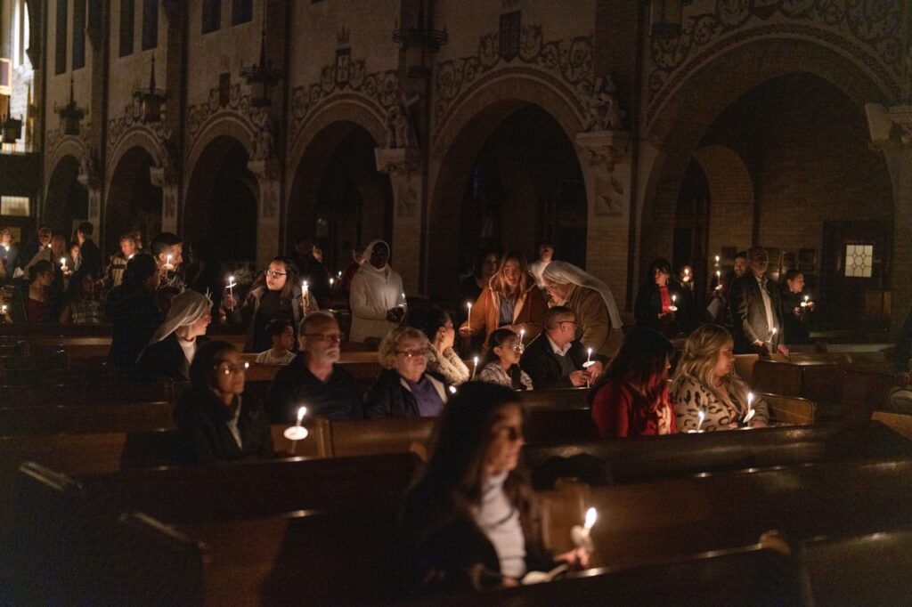 Congregation watches, with lit candles at the Easter Vigil 2024 at St. Dominic's. Photo by Brian Keith.