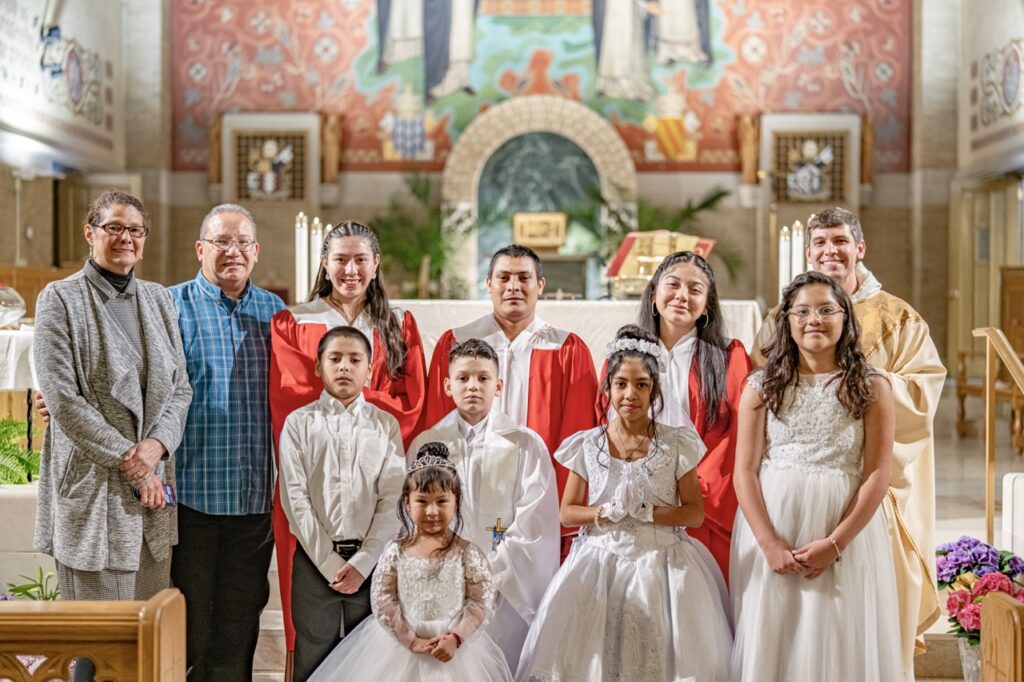 First communion class and confirmands pose with priest at the Easter Vigil 2024 at St. Dominic's. Photo by Brian Keith.