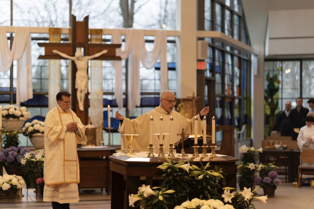 Priest welcomes congregants on Easter Sunday at Blessed Sacrament Parish in Warren. Photo by Brian Keith.