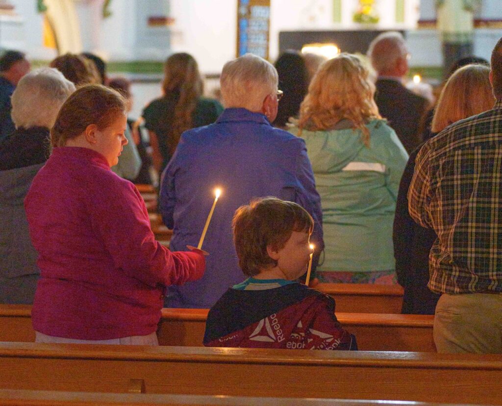 Young parishioners stand, holding candles at the Easter Vigil 2024 at Holy Trinity Parish in East Liverepool. Photo by Jimmy Joe Savage.