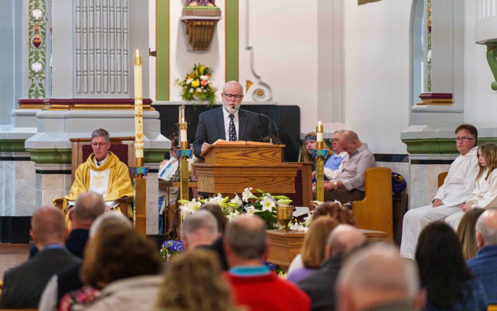 Lector reads from the ambo at the Easter Vigil 2024 at Holy Trinity Parish in East Liverepool. Photo by Jimmy Joe Savage.