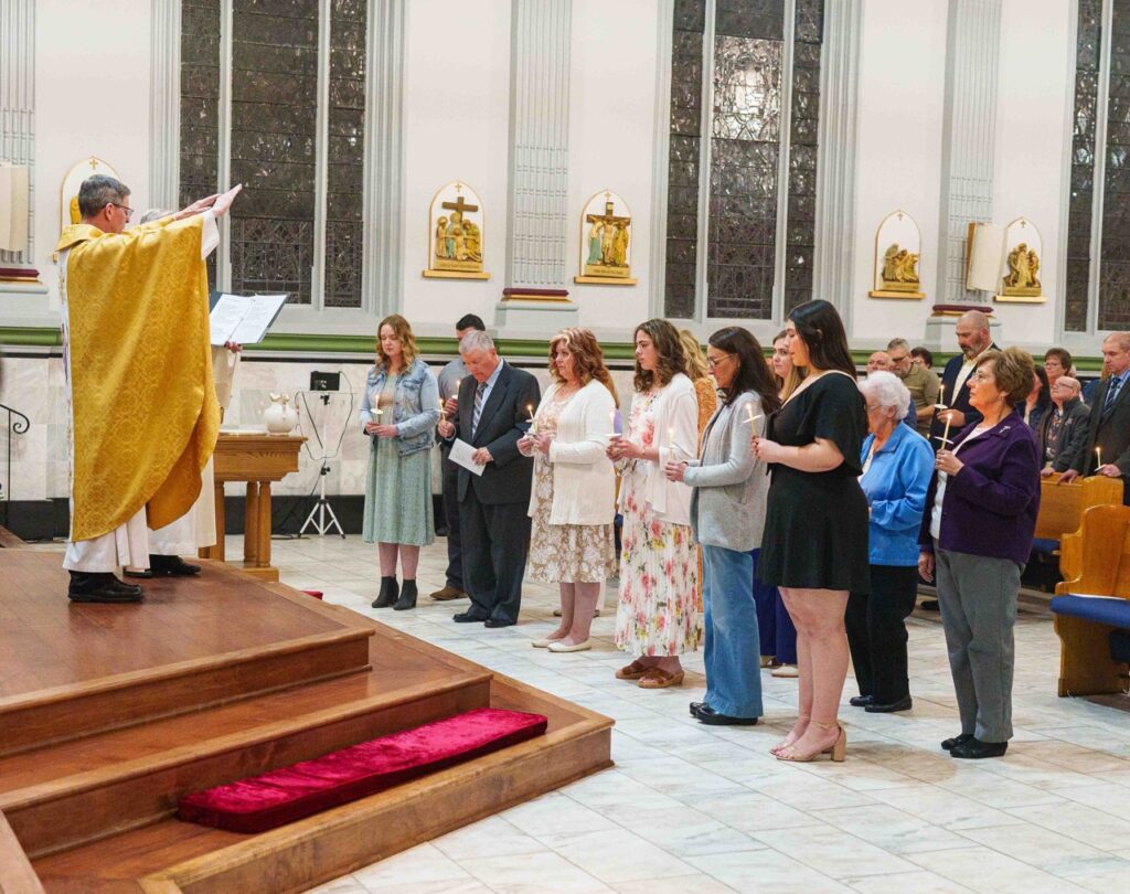 Priest leads the Confirmation rite at the Easter Vigil 2024 at Holy Trinity Parish in East Liverepool. Photo by Jimmy Joe Savage.