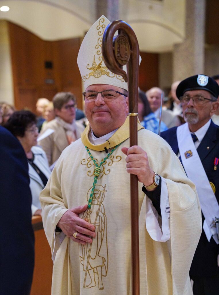 Bishop smiles at the camera, while processing in. Photo by Jimmy Joe Savage. Chrism Mass 2024.