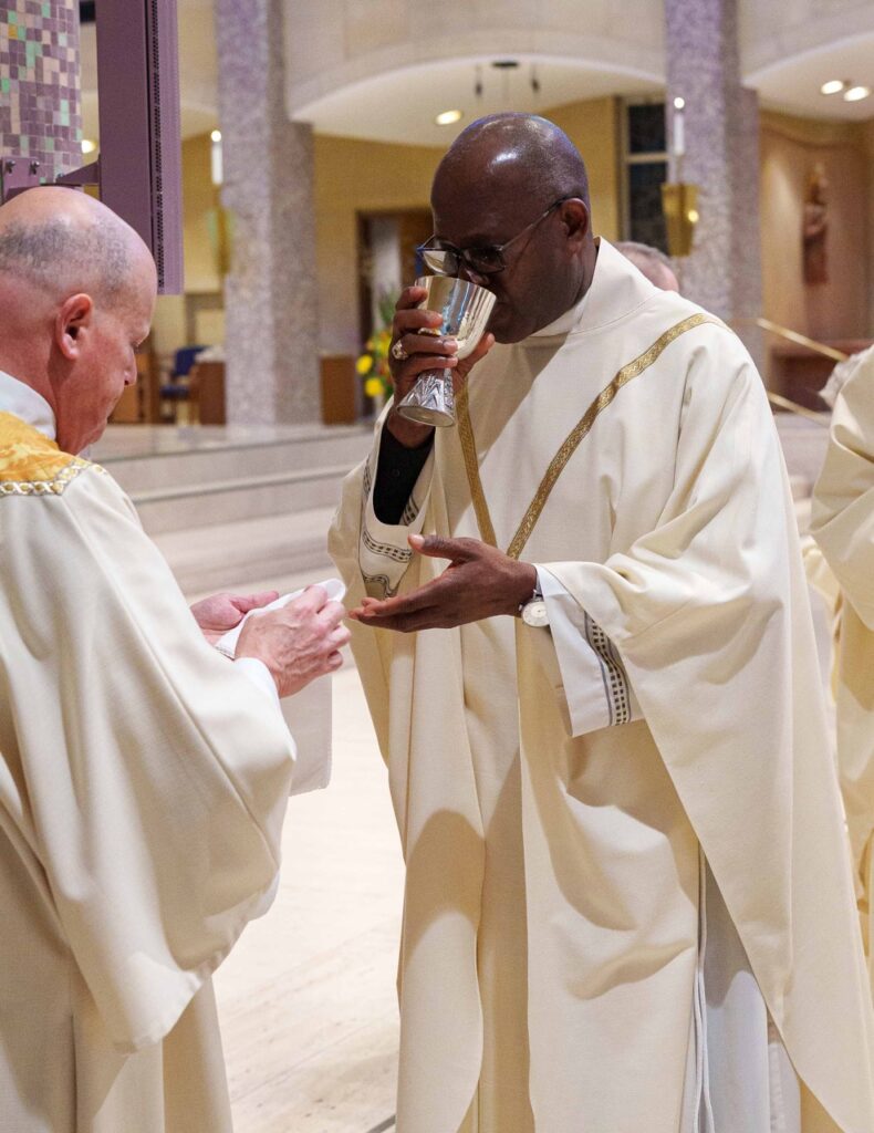 Priest receives communion. Photo by Jimmy Joe Savage. Chrism Mass 2024.