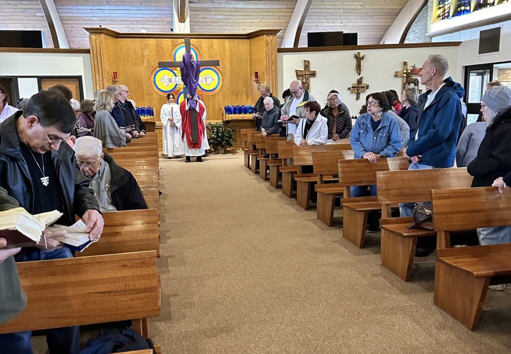 Father Thomas brings the cross forward for veneration during the Good Friday Liturgy 2024 at Our Lady of Peace Parish in Ashtabula. Photo by Marilou McClimans.