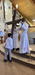 young boy kisses the cross at the Good Friday Liturgy 2024 at Our Lady of Peace Parish in Ashtabula. Photo by Marilou McClimans.