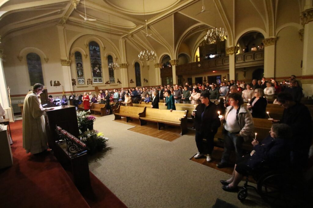 Congregation stands, holding candles at St. Joseph Parish in Mogadore during the Easter Vigil 2024. Photo by Ed Hall, Jr.