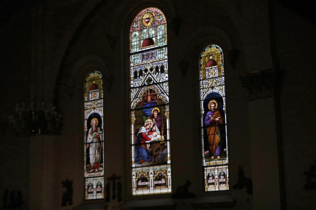 Beautiful stained glass windows shine in the darkness at St. Joseph Parish in Mogadore during the Easter Vigil 2024. Photo by Ed Hall, Jr.