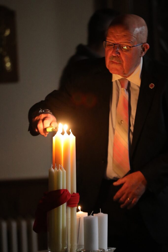 Man in a suit lights candles at St. Joseph Parish in Mogadore during the Easter Vigil 2024. Photo by Ed Hall, Jr.