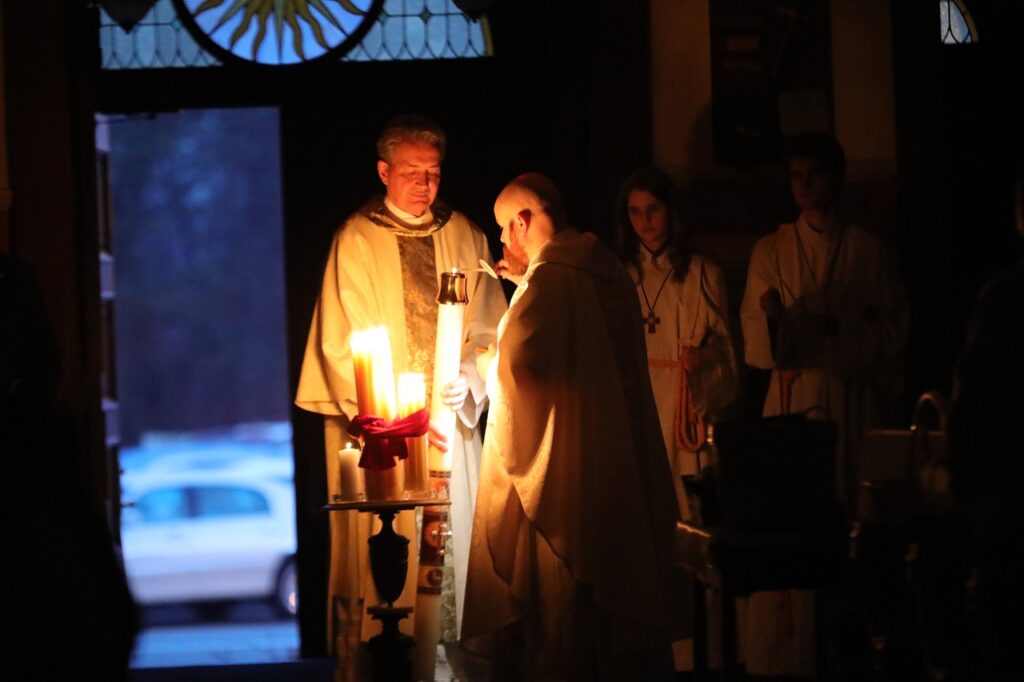 Priest uses the Easter candle to light congregants' candles at St. Joseph Parish in Mogadore during the Easter Vigil 2024. Photo by Ed Hall, Jr.