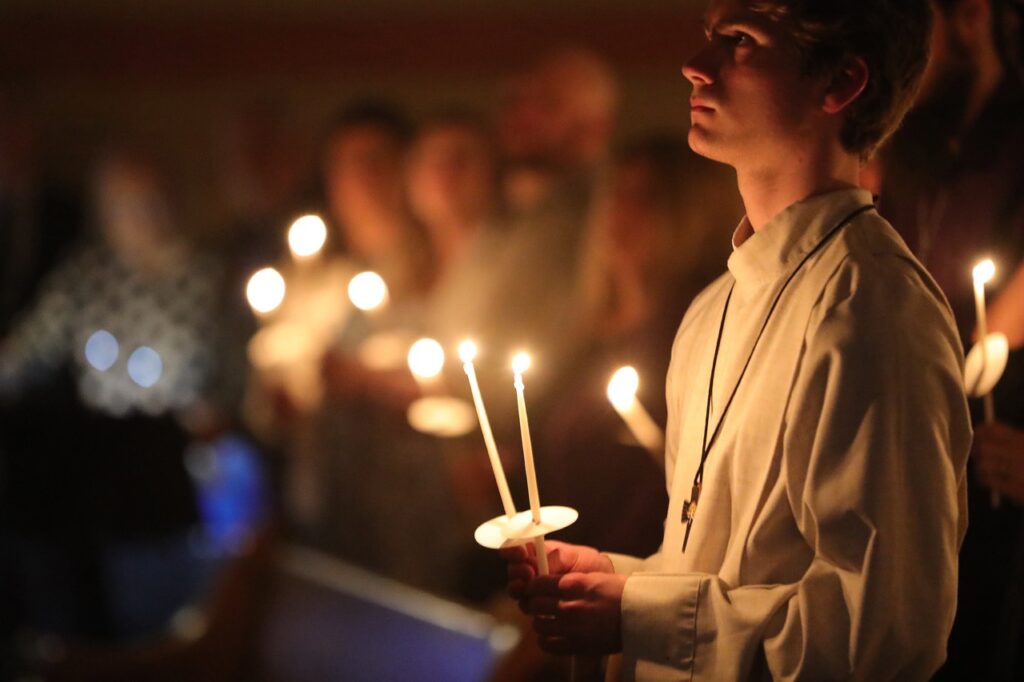 Young altar server stands with his candle at St. Joseph Parish in Mogadore during the Easter Vigil 2024. Photo by Ed Hall, Jr.
