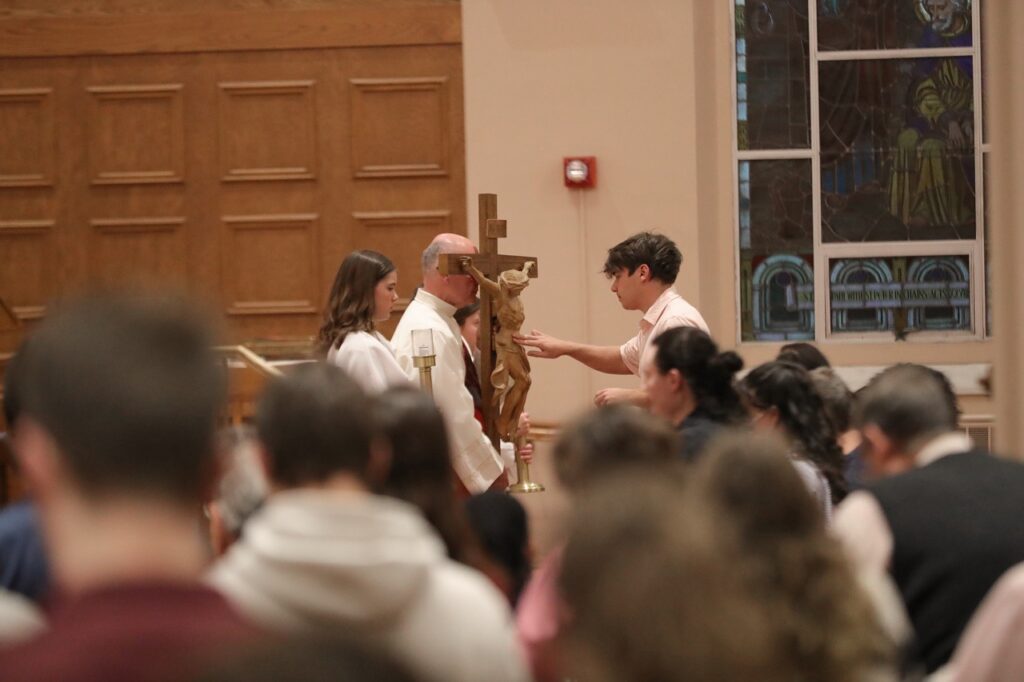 Young man venerates the cross at St. Paul Parish in North Canton on Good Friday 2024. Photo by Ed Hall, Jr.